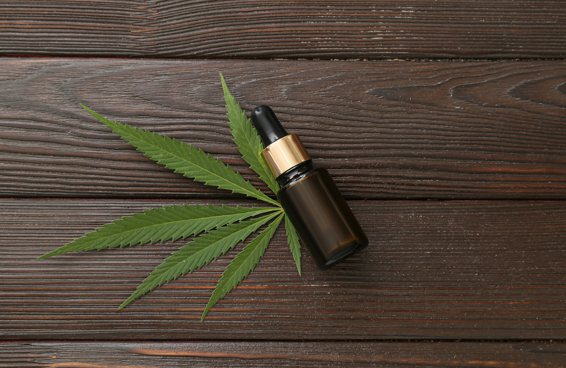 Bottle of CBD Oil on Wooden Background